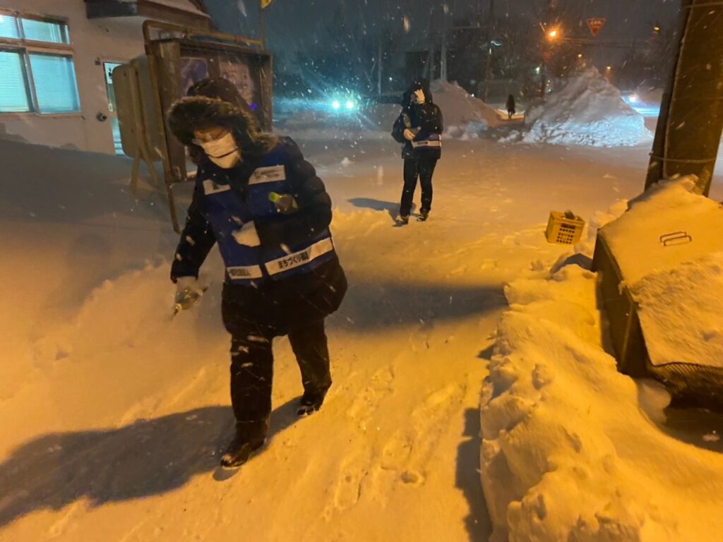 道路に砂まきをしている写真